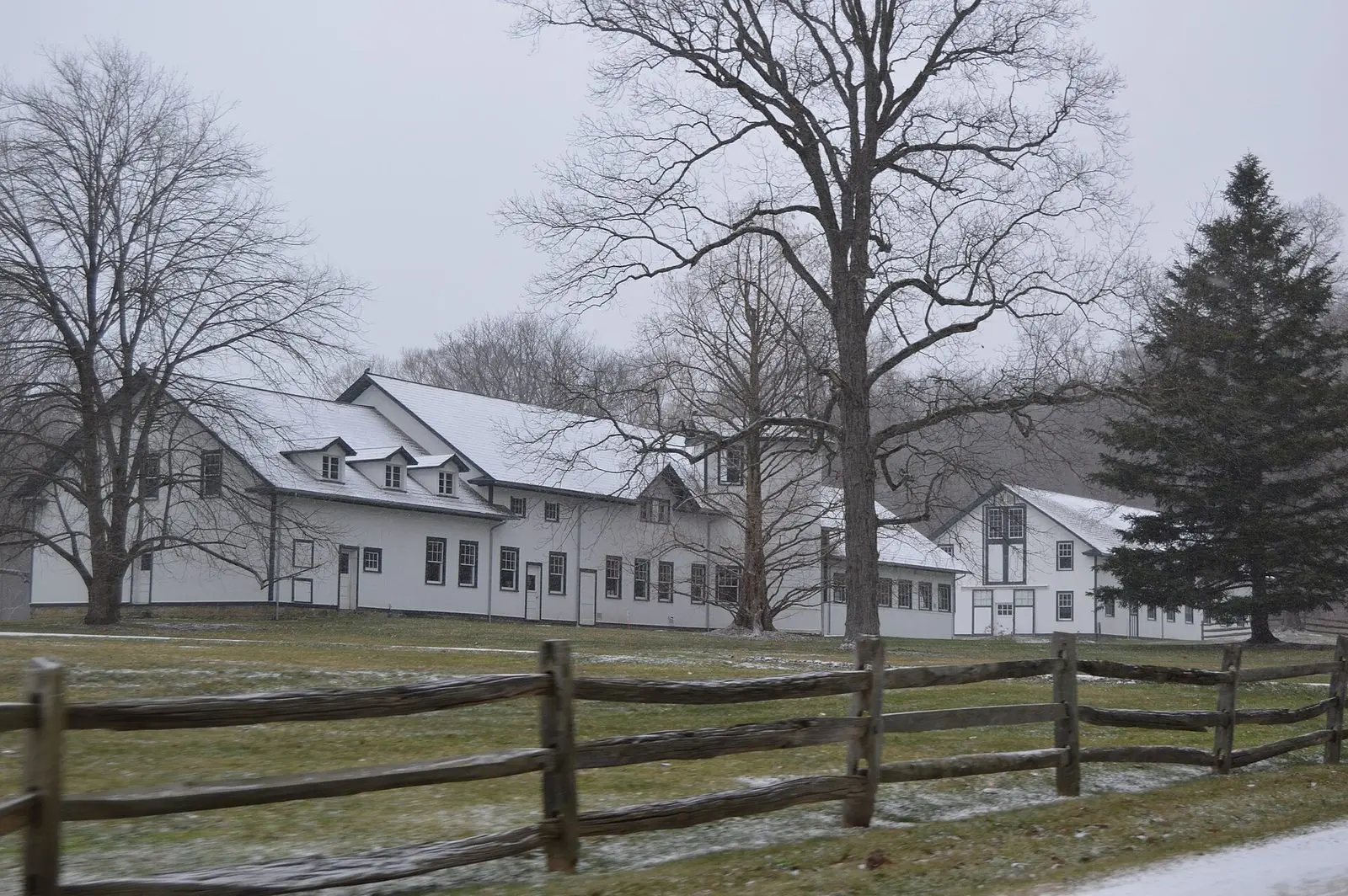 White farm buildings behind a split-rail fence in Hunting Valley
