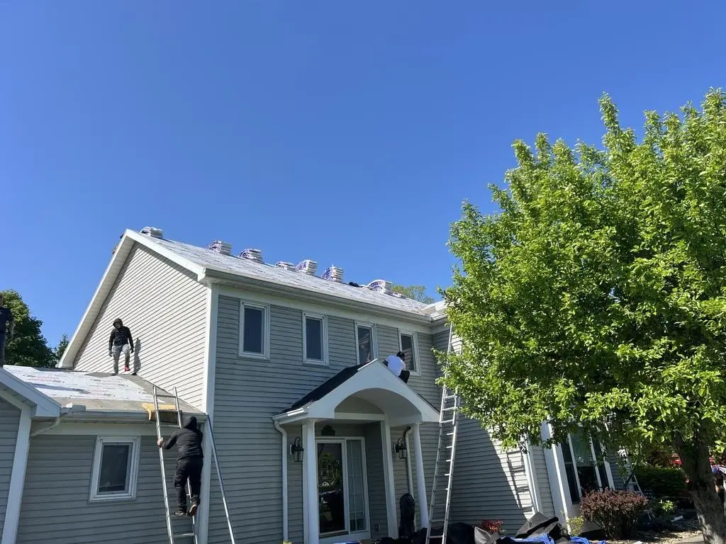 Roofing crew working on the front of a house