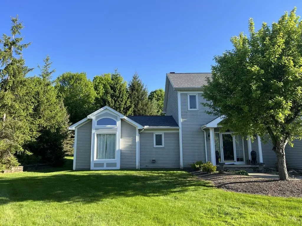 New shingle roof on a gray two-story house with a front porch