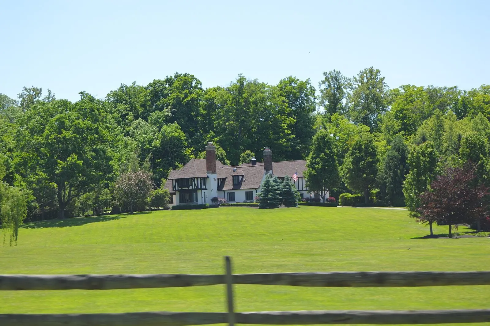 White estate house set back on a wide lawn in Kirtland Hills