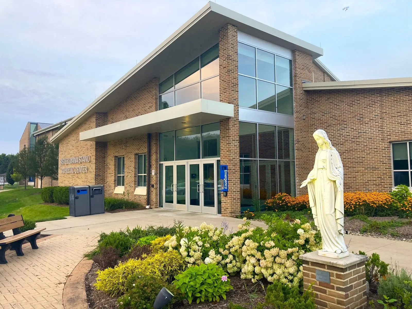 Flower gardens and a statue of Mary outside a building on the Ursuline College campus in Pepper Pike
