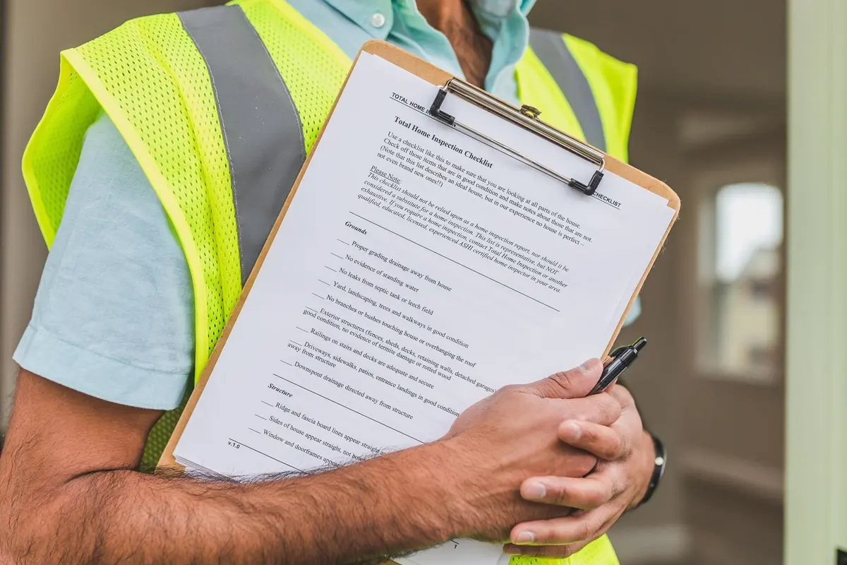 Inspector in a safety vest holding a clipboard with an inspection checklist